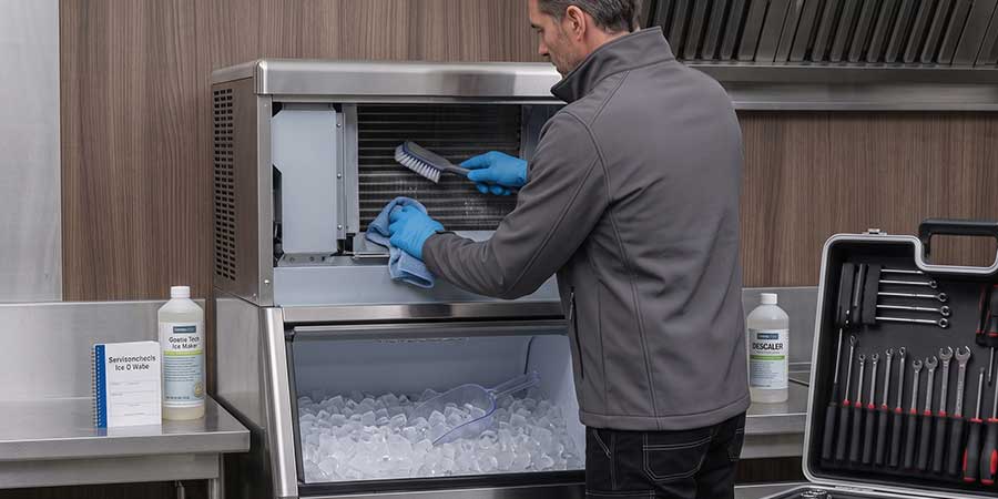 Techniker reinigt eine Eiswürfelmaschine in einer Gastroküche