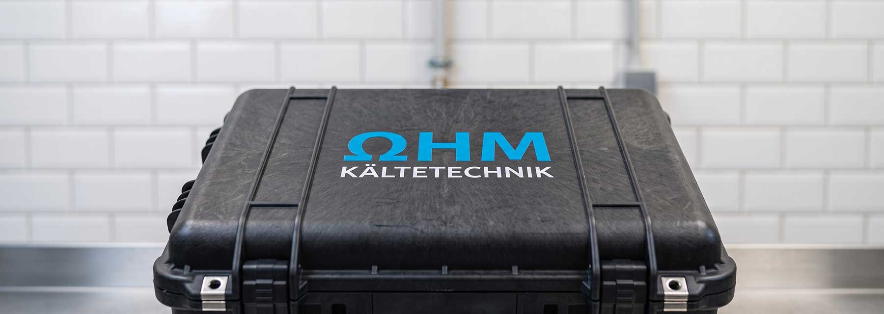 Servicekoffer von Ohm Kältetechnik vor einer gefliesten Wand als Symbol für den professionellen Einsatz vor Ort