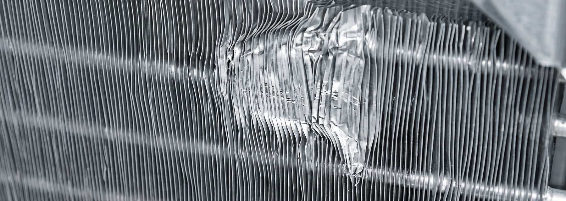 Zusammengedrückte und verbogene Aluminiumlamellen eines Kondensators nach unsachgemäßer Reinigung