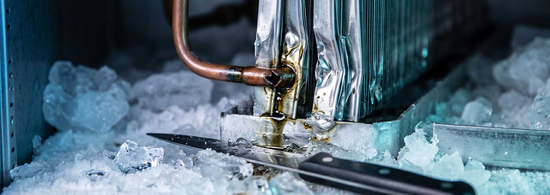 Beschädigte Lamellen und angestochene Kältemittelleitung an einem Verdampfer nach Eisentfernung mit dem Messer